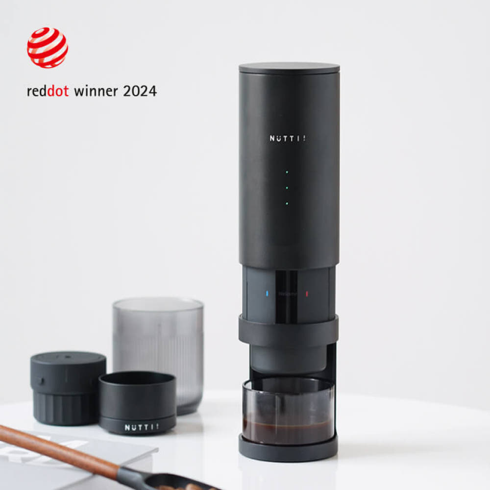 Black coffee maker with 'NUTTI' branding on a white background, featuring Red Dot Award logo.