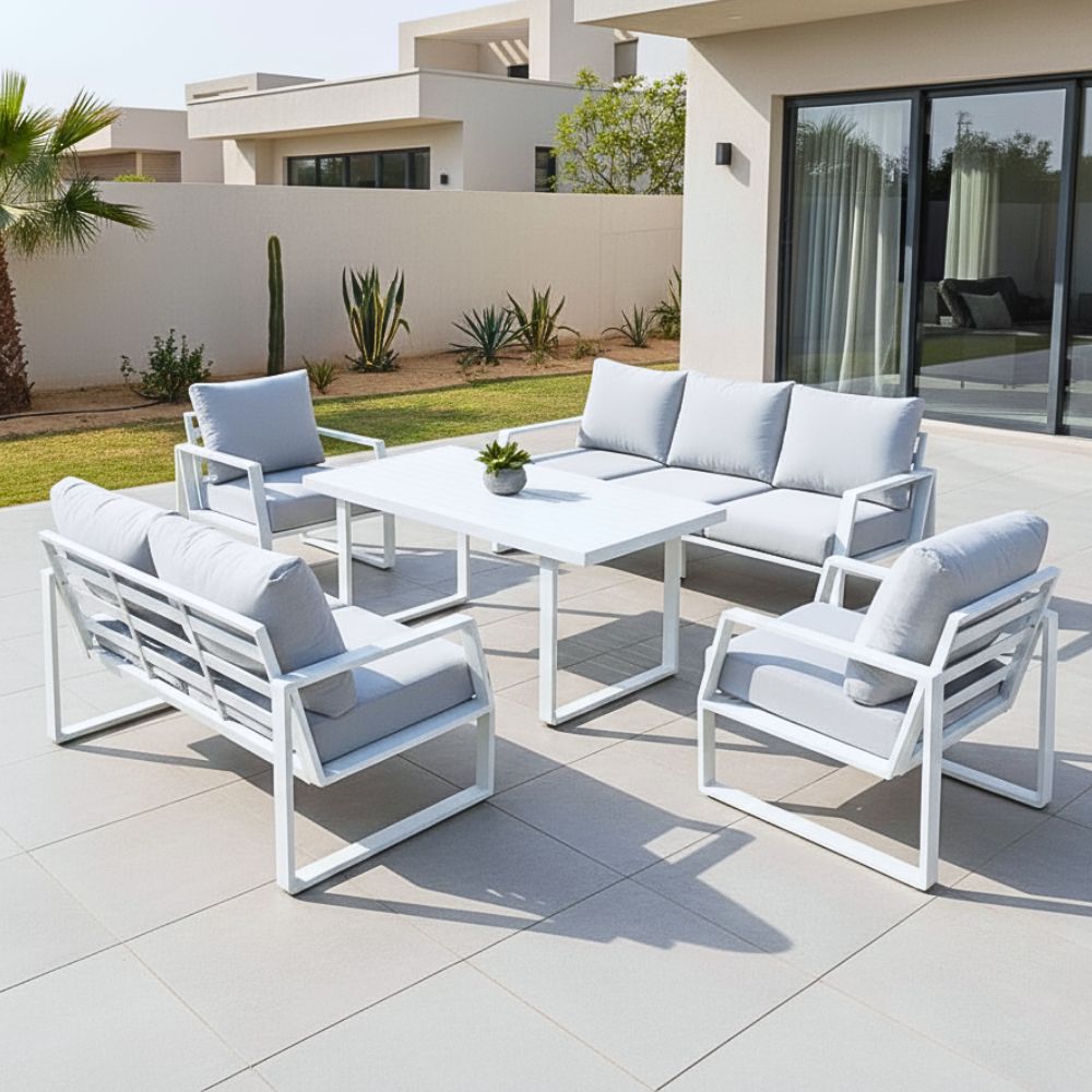 Outdoor patio set with white chairs and table on a tiled patio.